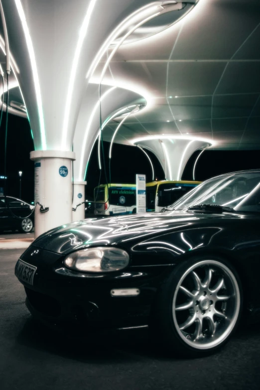 a black car parked in a parking garage with streaks of lights