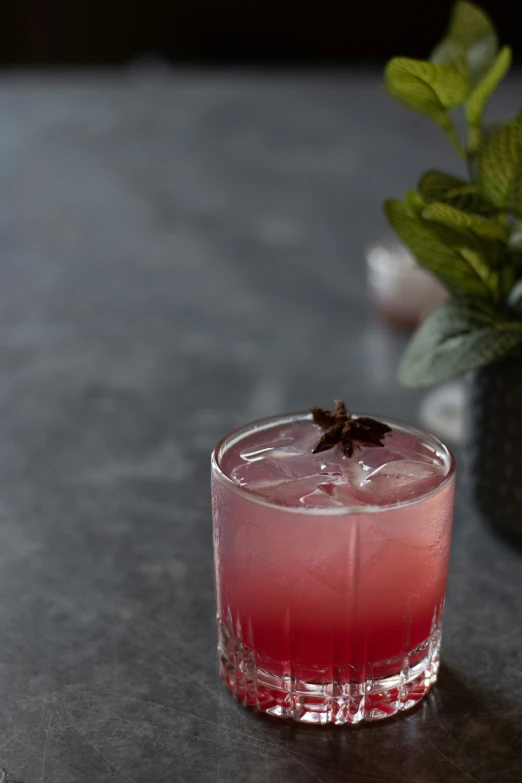 a pink colored beverage in a glass on a table