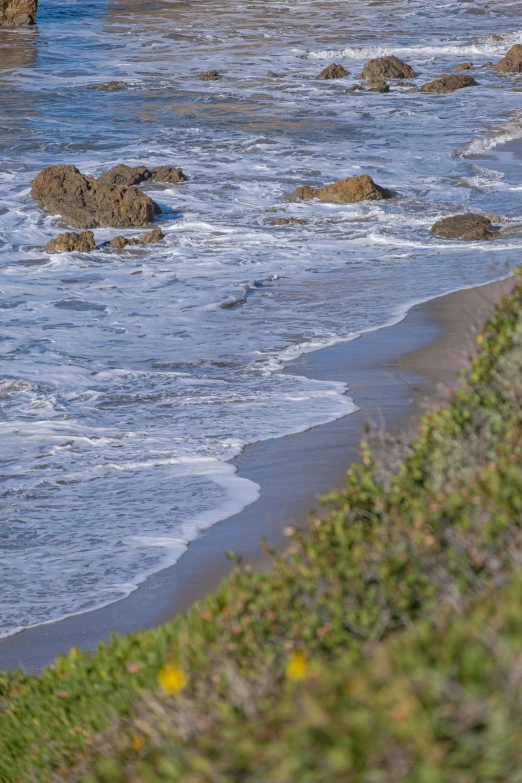 a black beach with water flowing towards the shore