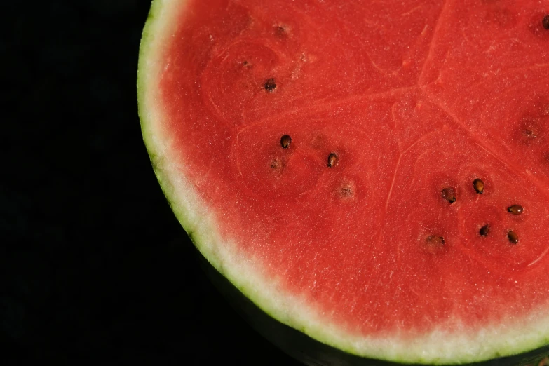 a red piece of watermelon is on the black background