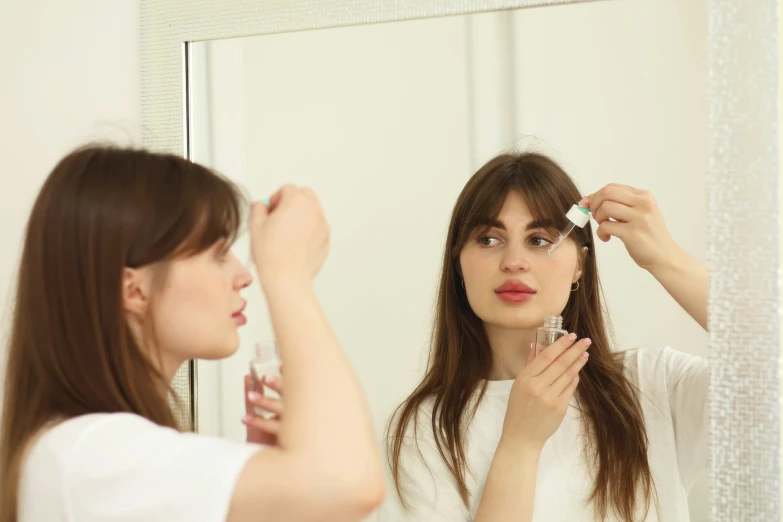 the young woman is brushing her hair in front of the mirror