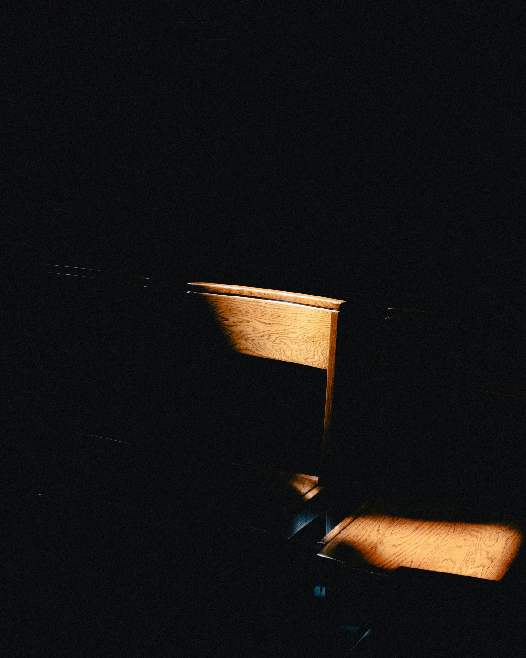 a wooden chair and the floor is dark