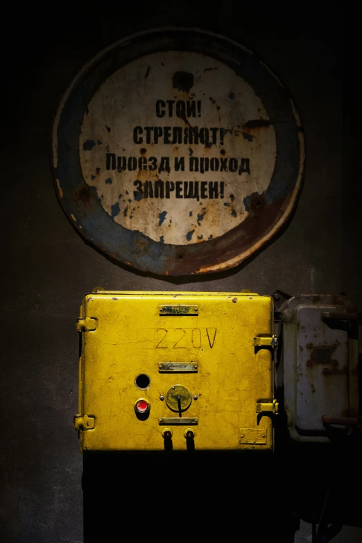 an old sign sits in front of a yellow suitcase
