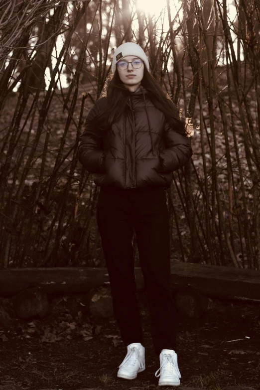 a person standing next to a bush with snow