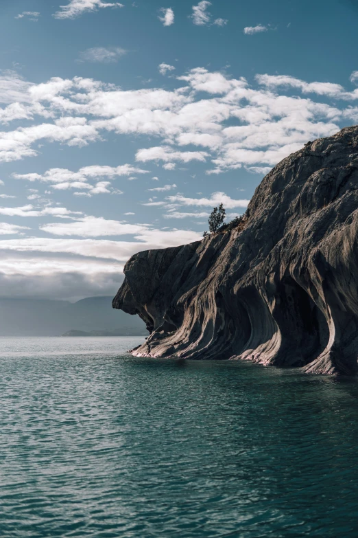 an image of a rocky cliff in the middle of the ocean