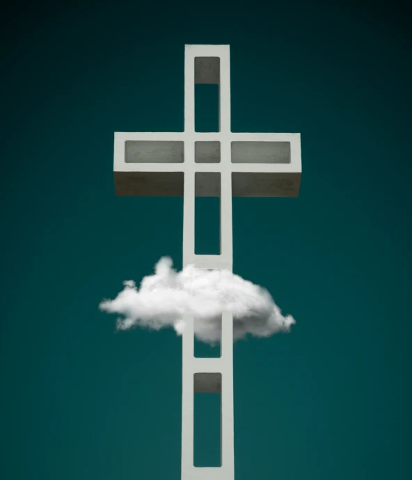 a white building has a cloudy cross above it