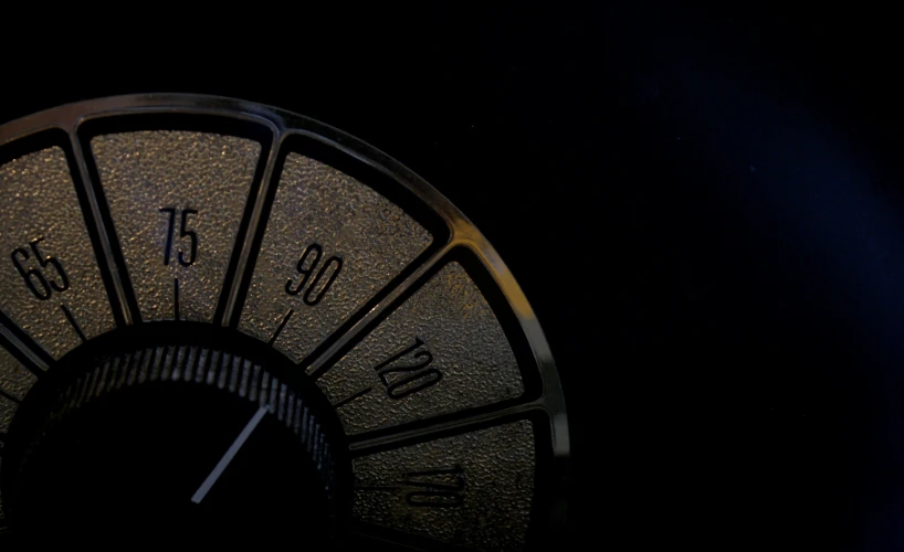 a close up of a circular clock in the dark