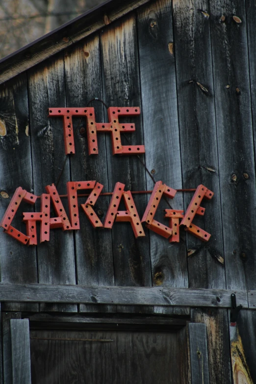 the garage sign is displayed in front of a wooden building