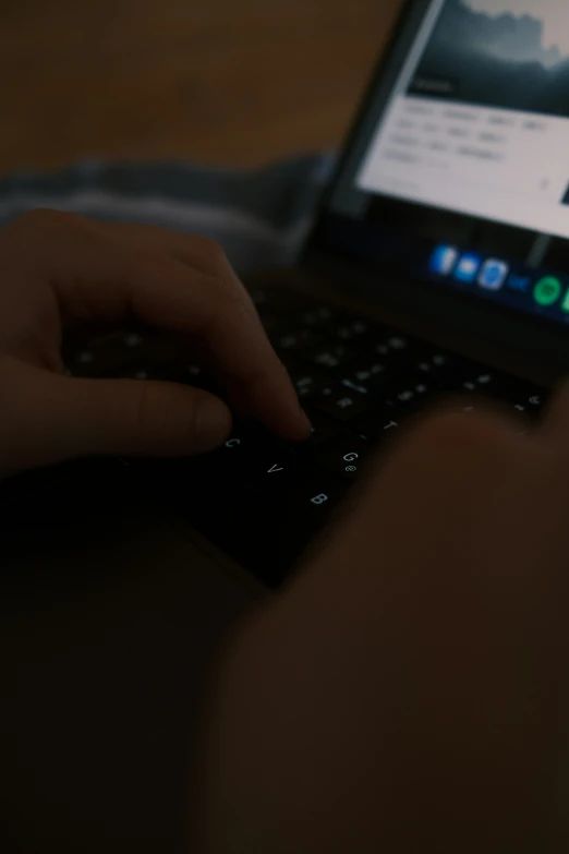 a person is typing on their laptop keyboard