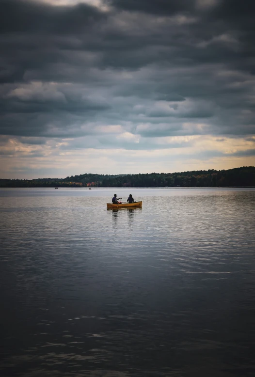 two men are rowing a canoe on the lake