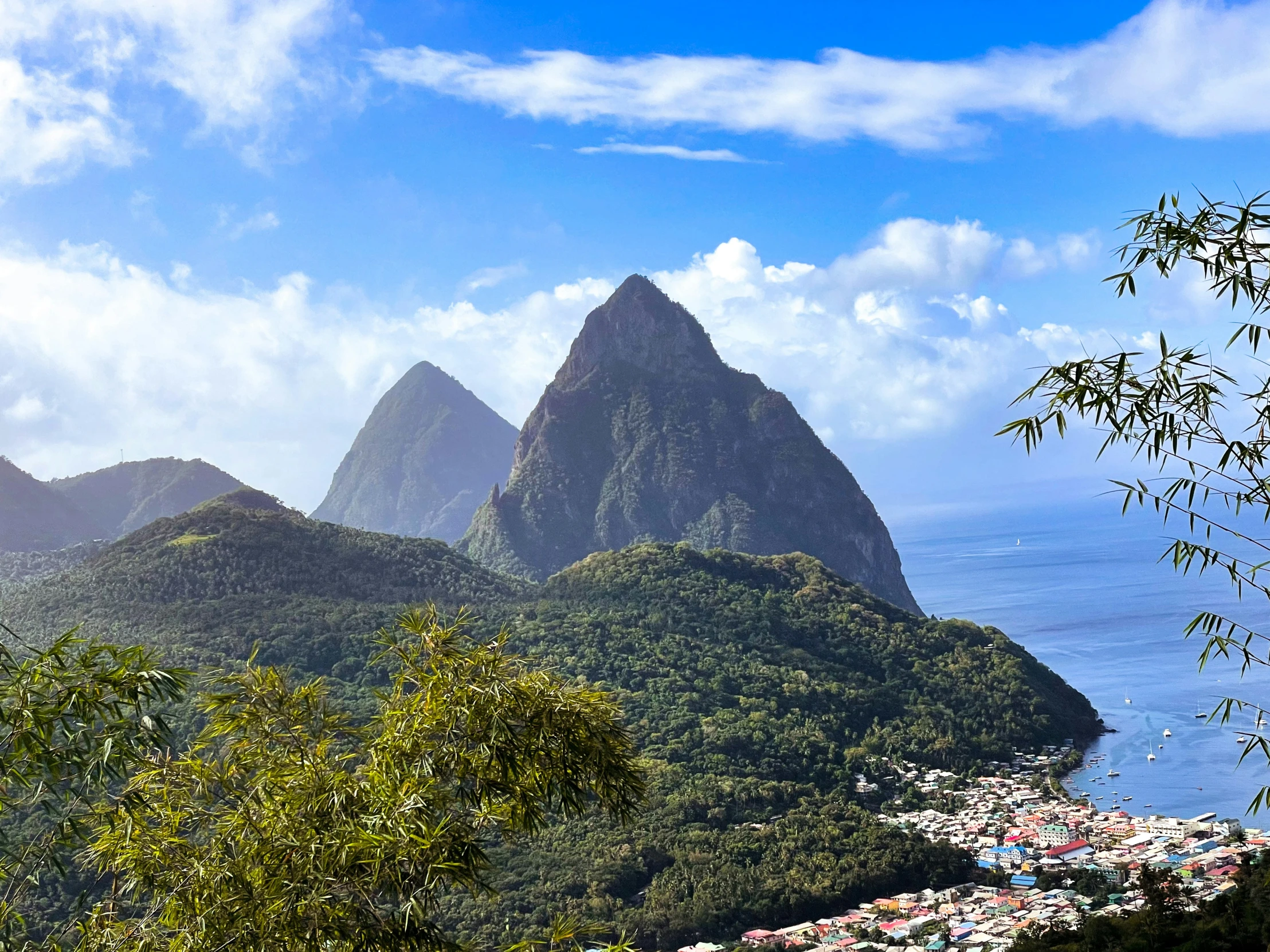 two mountain peaks and trees, with clouds in the background