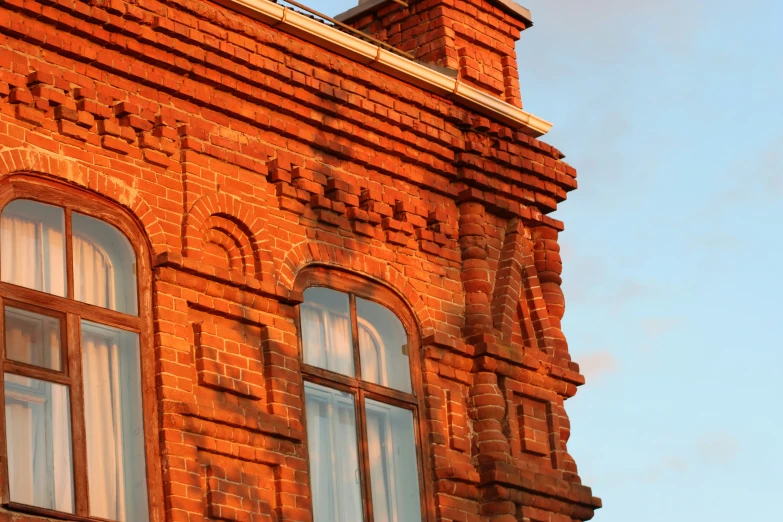 the windows of an old brick building against a blue sky