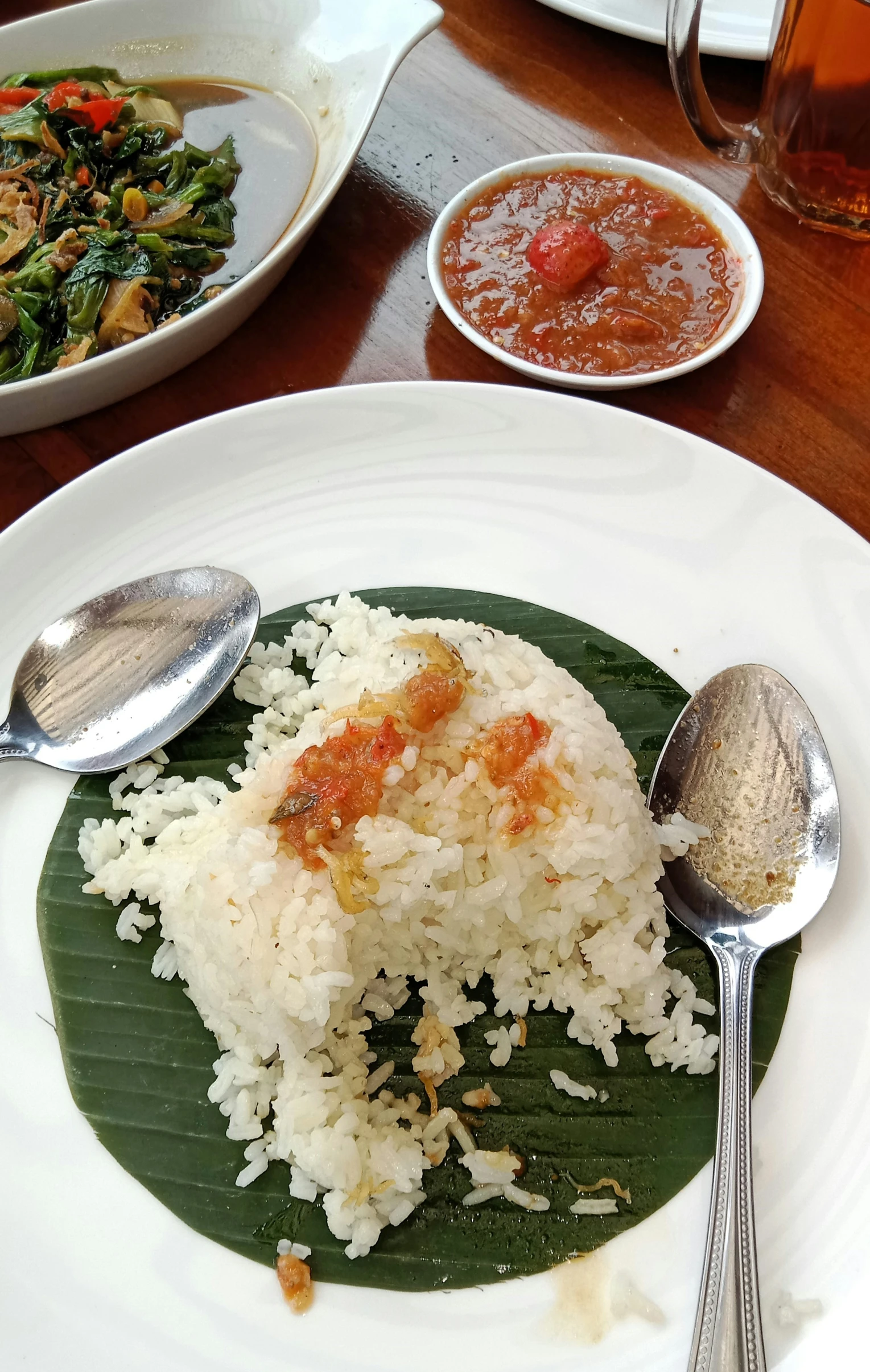 a plate with rice, meat and vegetables with silver ware