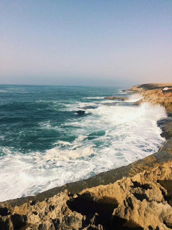 the surf is crashing against the cliffs of the beach