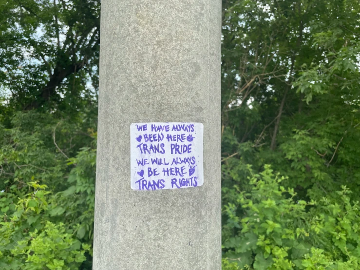 a sign is written on the side of the tree