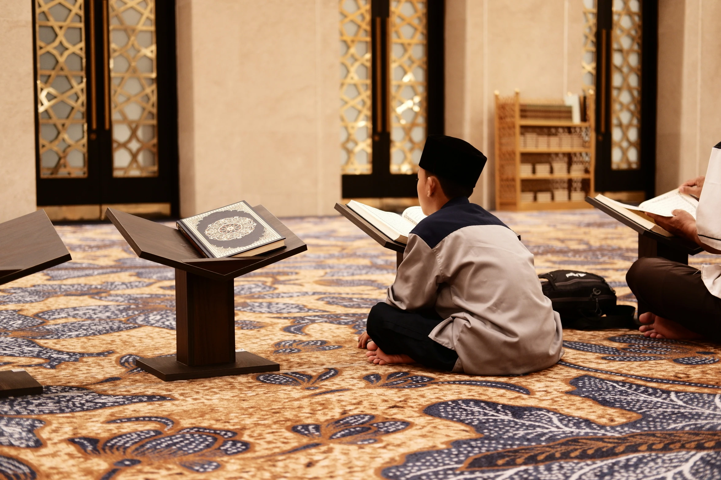 two men are reading on the floor in an empty room