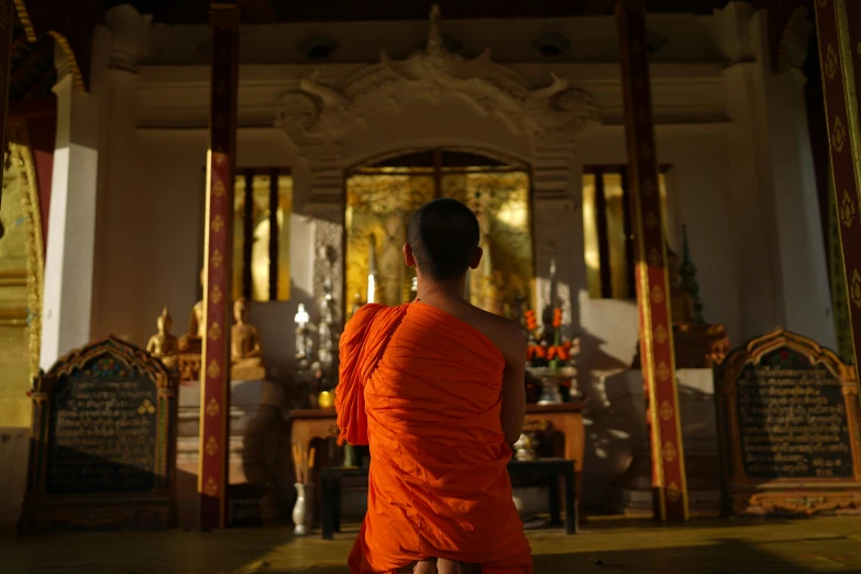 a woman in an orange cloth is walking towards the door