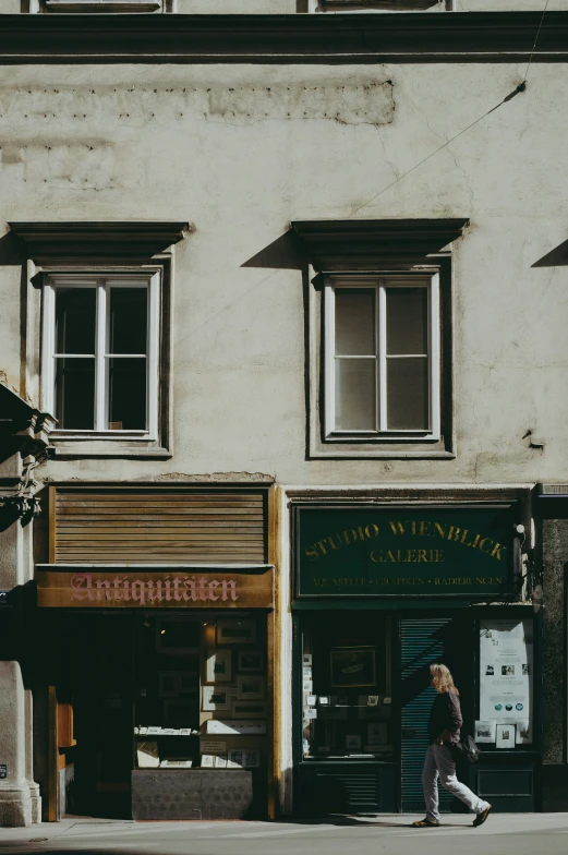 a person that is walking past some buildings