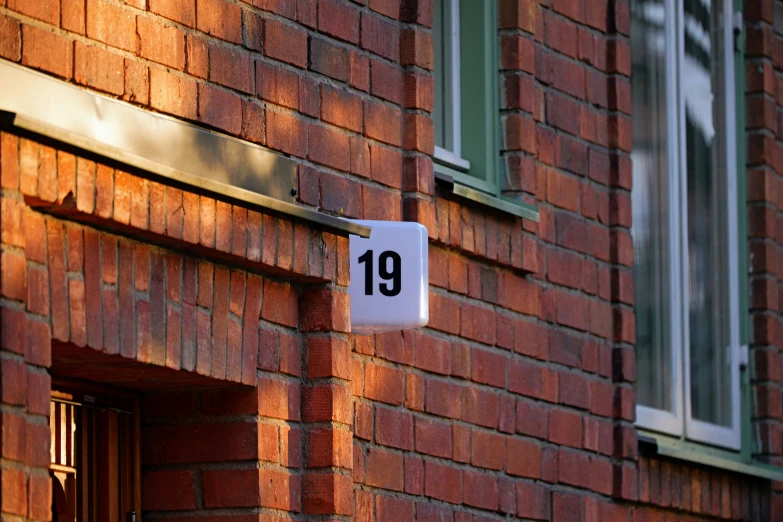 brick building with a sign on it stating the number 19