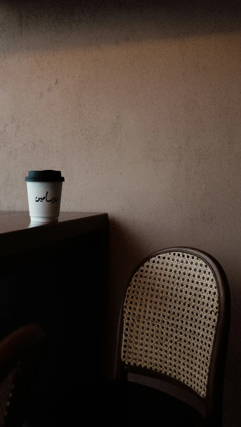 coffee cup sitting on top of a table next to a chair