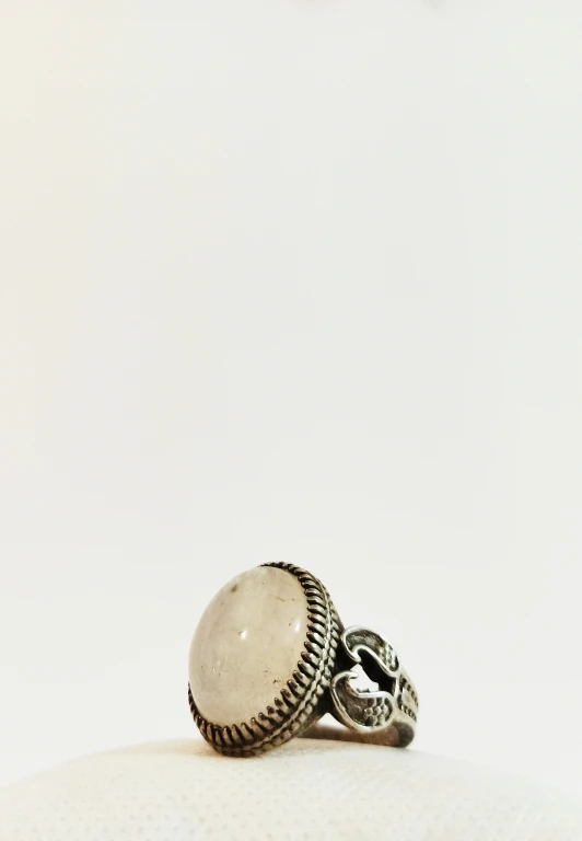 a white stone ring with two black skull heads