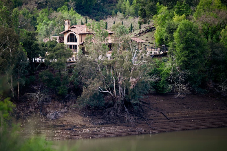 a mansion on top of a hill next to the water