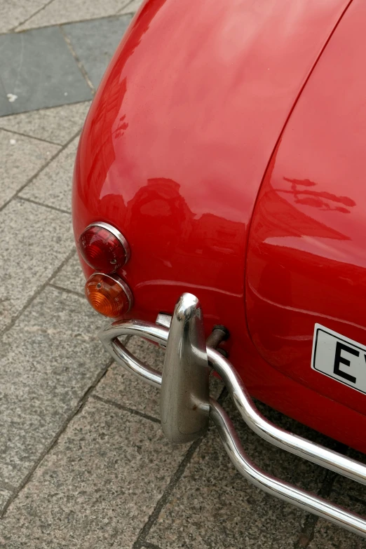 a very bright red car parked on the pavement