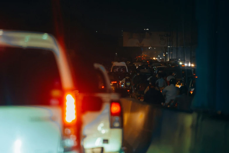 a night scene looking down the road as people are traveling in vehicles