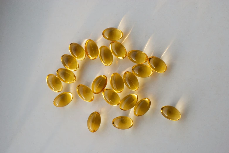 fish oil capsules are scattered on a light gray surface