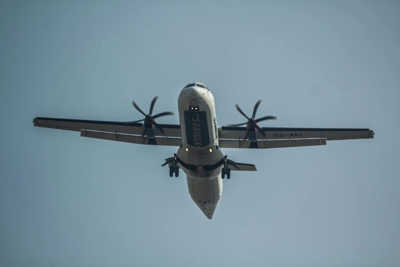 an airplane flying through the air with four propellers