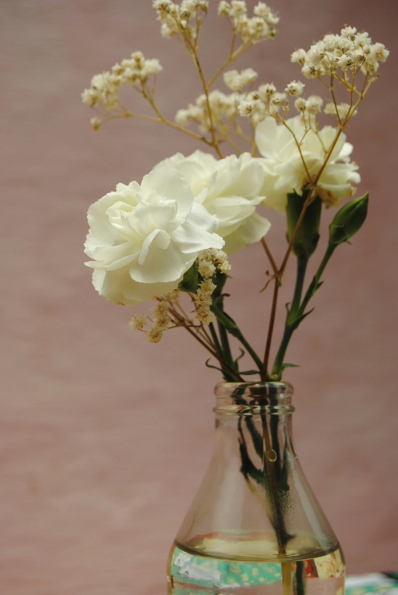 white flowers in a clear glass vase on a table