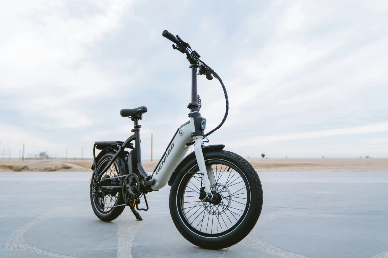 a grey bicycle sitting in the middle of an empty parking lot