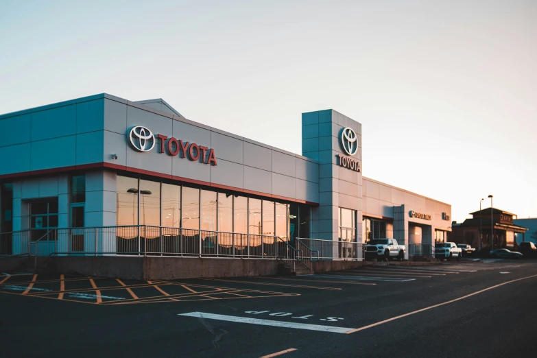 a toyota dealership with the sun setting behind it