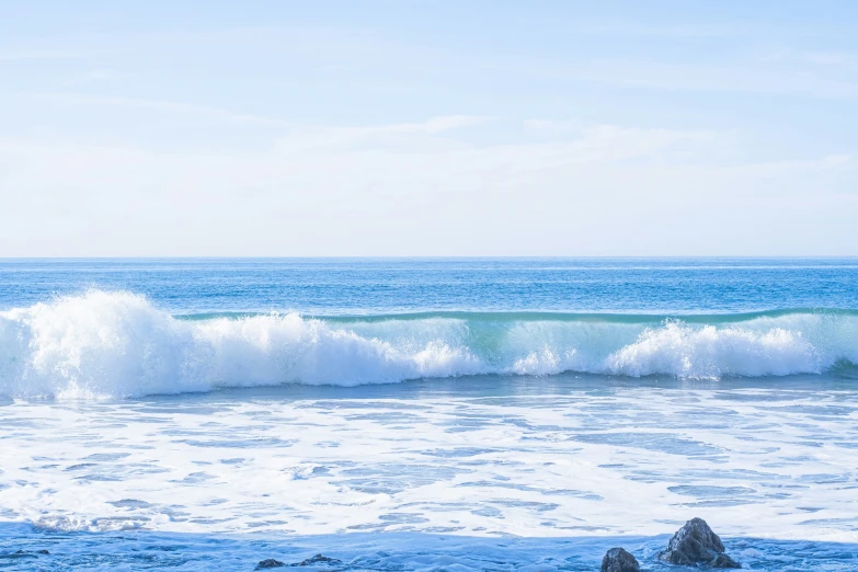 an ocean is shown with the sky and ocean waves