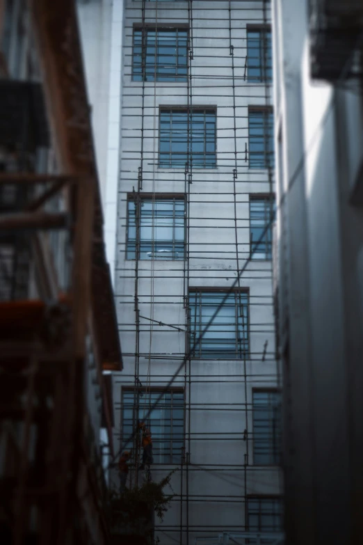 a building with scaffolding and windows is behind another one