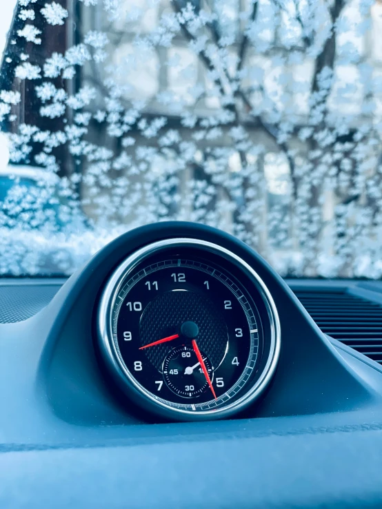 a blue dashboard with snow on it is next to a window