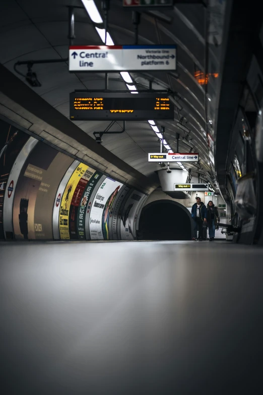 a subway tunnel with people waiting for the train