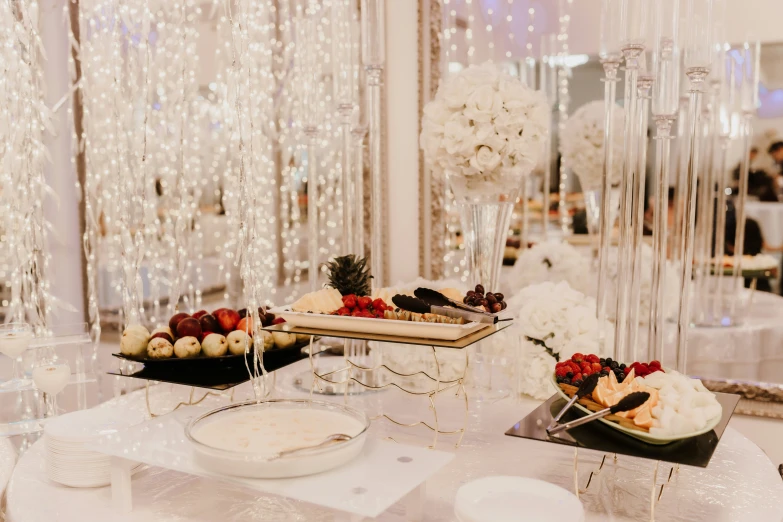 an elegant dessert table with flowers and place settings