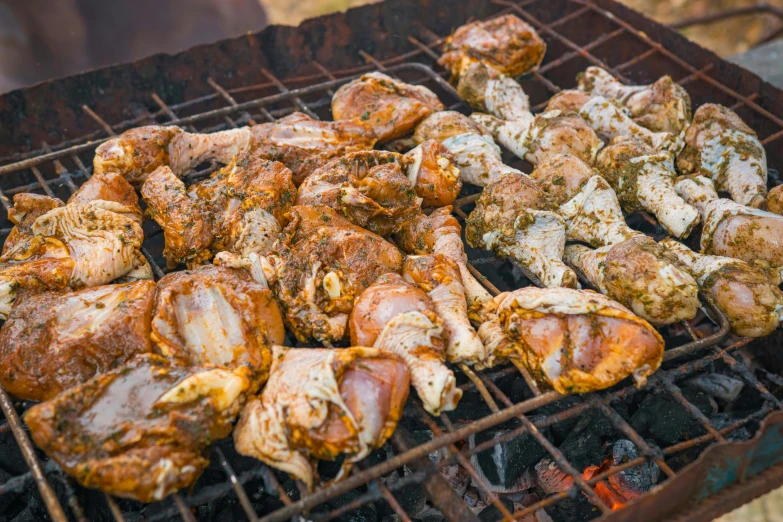 chicken is cooking on the grill and it's smothered in spices