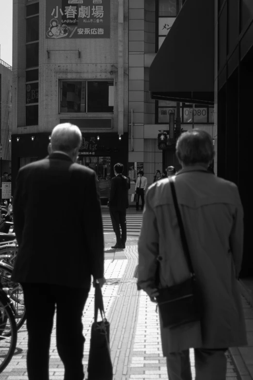 people are walking down a sidewalk carrying bags