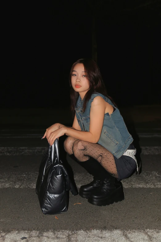 a woman sitting on the ground with her hand in a bag