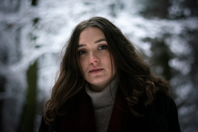 a woman is standing in the middle of a snow covered woods