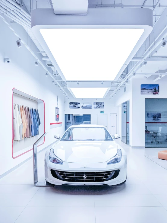 the front end of a white sports car in a garage