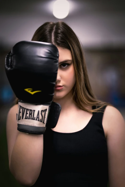 a girl wearing a boxing glove while posing for a picture