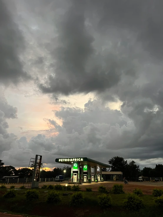 a gas station under a cloudy sky,