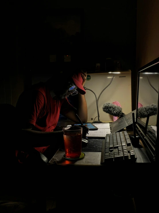 a person sitting in front of a computer in the dark