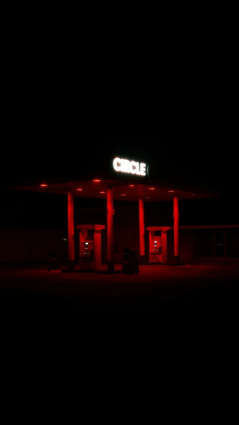gas station lit up at night time with bright red lights