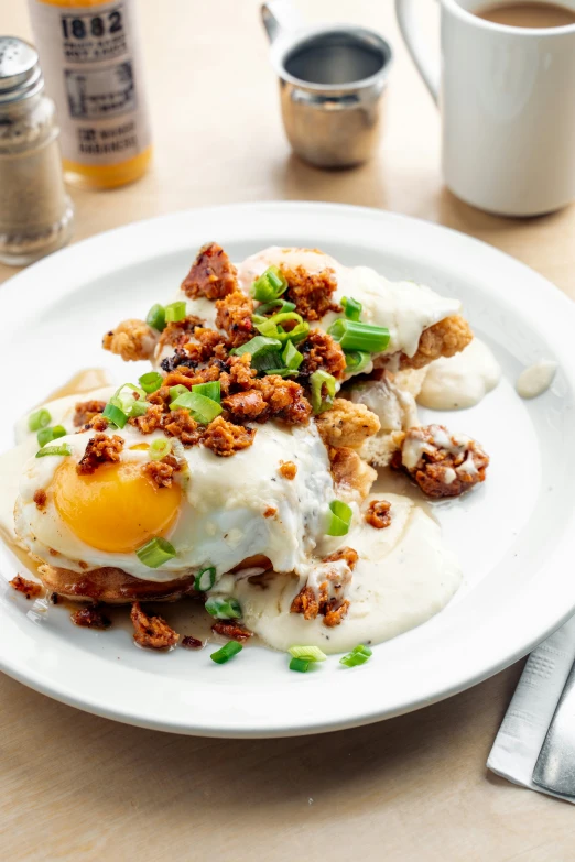 an open faced dish with fried eggs and green onions