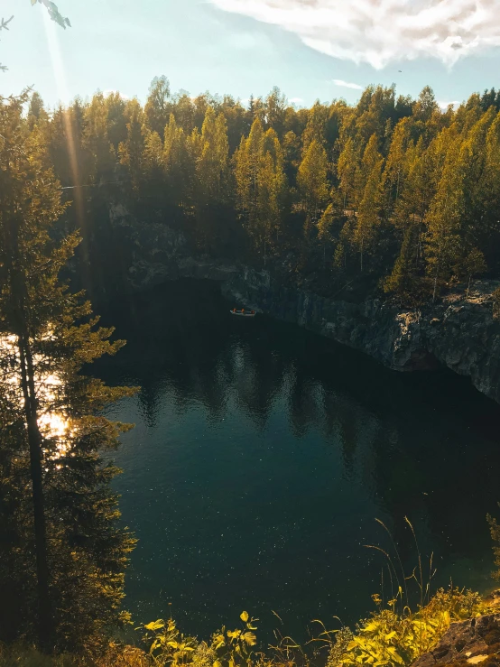 the sun is shining on the water in a small lake