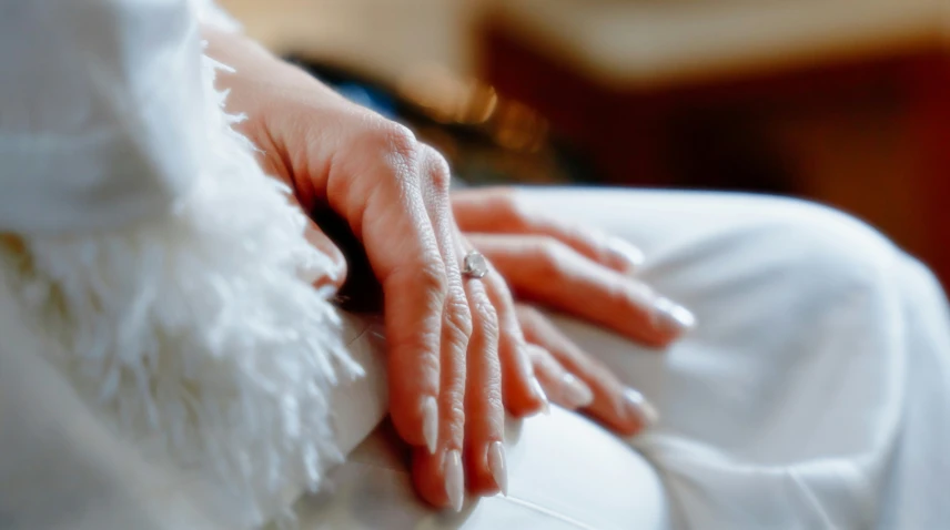 a person's hands that are sitting on a chair